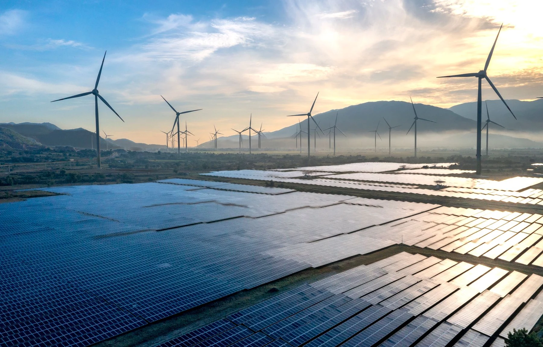 Panel surya dan turbin angin dalam lanskap senja - foto stok ilustratif, bukan proyek atau dukungan Greenova Energi